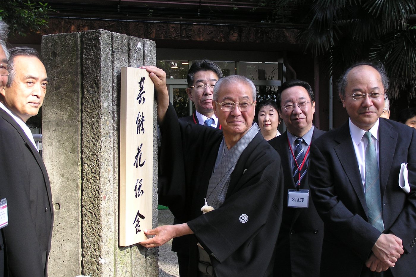 看板を取りつける野村会長